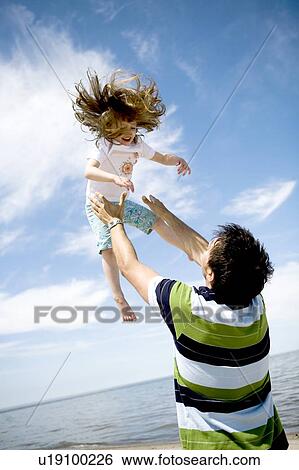 Man throws girl (4) up into air, Grand Beach Provincial Park, Manitoba, Canada View Large Photo Image Stock Photograph - Man throws girl (4) up into air, Grand Beach Provincial Park, Manitoba, Canada. Fotosearch