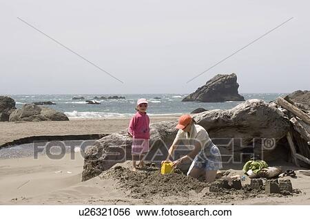 Mother and daughter play in sand on beach, Harris Beach State Park, Oregon, USA View Large Photo Image Stock Photograph - Mother and daughter play in sand on beach, Harris Beach State Park, Oregon, USA. Fotosearch