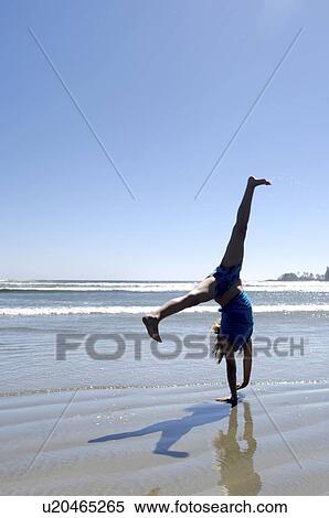 Pre-teen girl performing cartwheel on beach, Vancouver Island, Canada View Large Photo Image Stock Photography - Pre-teen girl performing cartwheel on beach, Vancouver Island, Canada. Fotosearch