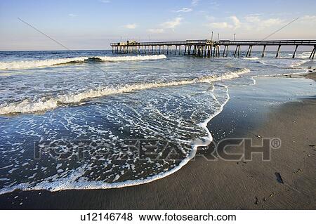 Stock Photo - View of beach and pier at sunset, New Jersy, USA. Fotosearch