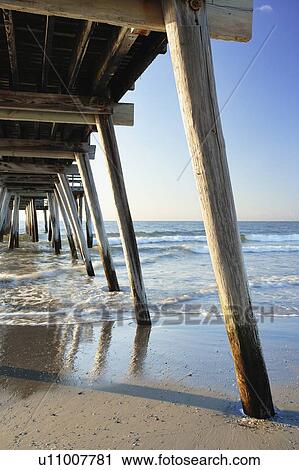 Stock Image - View of pier and beach at sunrise, New Jersy, USA.. Fotosearch