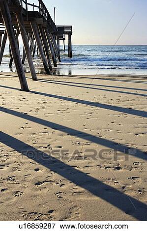 Stock Photo - View of pier and beach at sunrise, New Jersy, USA. Fotosearch
