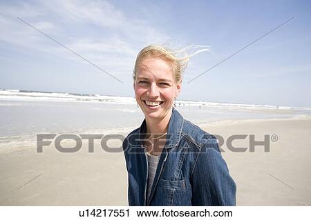 Stock Image - Woman (35) walking on the beach, Jacksonville, Florida. Fotosearch