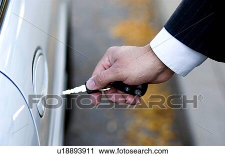 Stock Image - Businessman locking or unlocking car door. Fotosearch