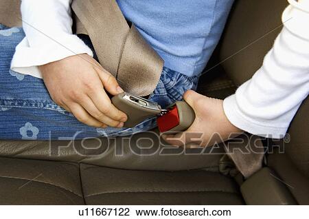 Stock Image - Child buckling seatbelt. Fotosearch