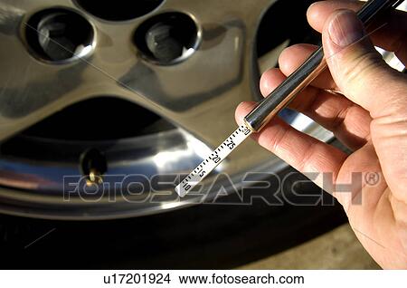 Picture - Man checking tire pressure. Fotosearch