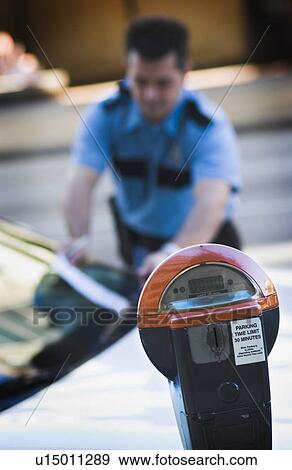 Stock Photo - Policeman writing parking ticket. Fotosearch