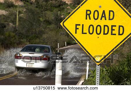 Stock Photography - Vehicle driving on flooded road. Fotosearch