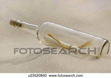 Stock Image - Message in a bottle on beach. Fotosearch
