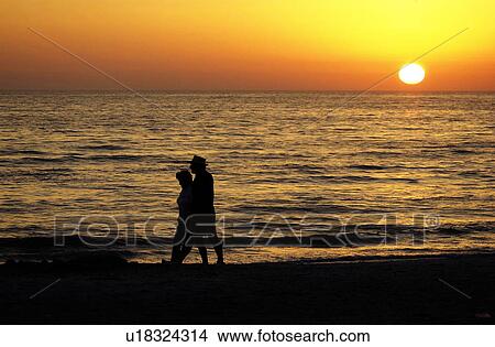 Senior couple holding hands and walking on beach View Large Photo Image Picture - Senior couple holding hands and walking on beach. Fotosearch