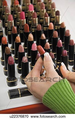 Stock Image - Woman shopping for lipstick. Fotosearch