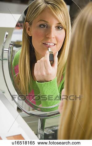 Stock Photography - Woman testing lipstick in retail store. Fotosearch