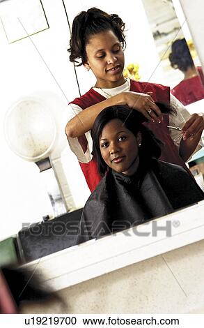 Stock Image - African American woman getting a haircut. Fotosearch