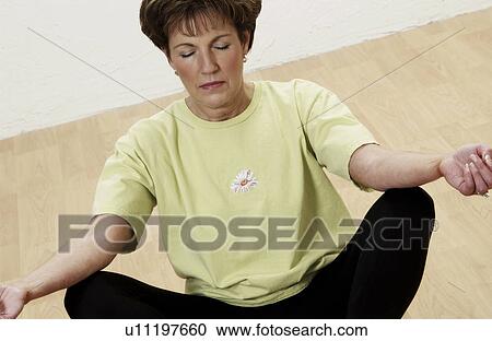 Stock Image - Senior woman doing yoga. Fotosearch