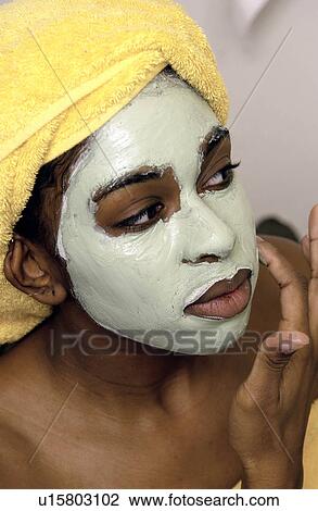 Stock Image - Woman applying a mask. Fotosearch