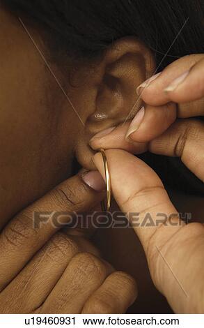 Woman putting on earring View Large Photo Image Stock Image - Woman putting on earring. Fotosearch