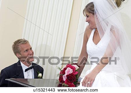 Stock Image - Bride and groom at piano. Fotosearch