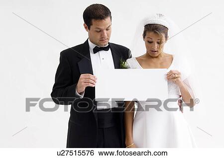 Bride and groom holding blank sign View Large Photo Image Stock Photograph - Bride and groom holding blank sign. Fotosearch