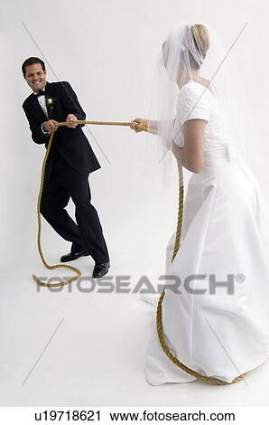 Bride and groom playing tug of war View Large Photo Image Stock Image - Bride and groom playing tug of war. Fotosearch