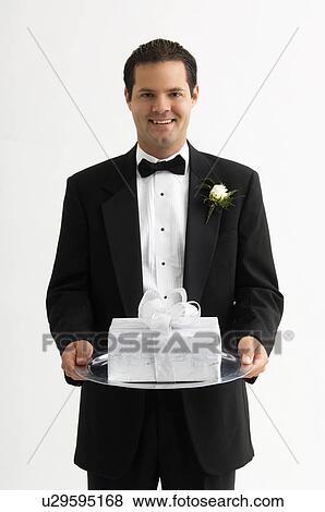 Stock Photo - Man holding gift on silver platter. Fotosearch