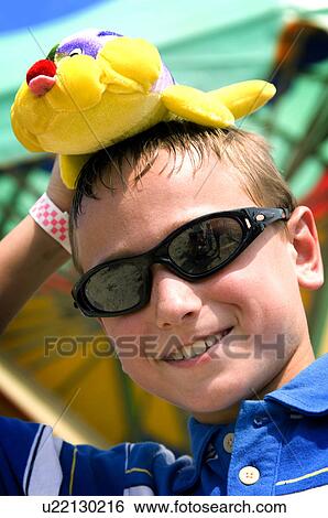 Stock Photograph - Boy holding stuffed animal at carnival. Fotosearch