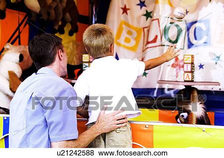 Father and son playing carnival game View Large Photo Image Stock Photo - Father and son playing carnival game. Fotosearch