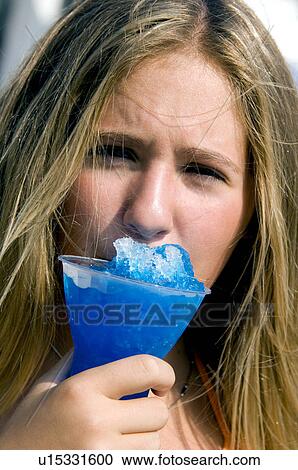 Stock Image - Girl eating carnival food. Fotosearch