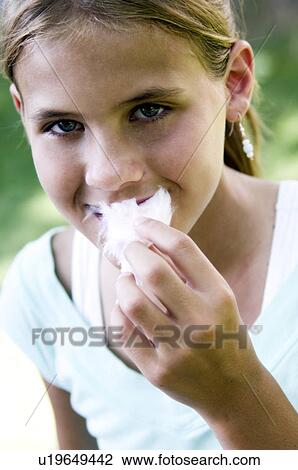Stock Image - Girl eating cotton candy. Fotosearch