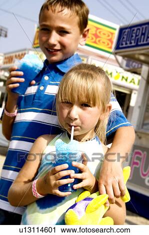 Stock Image - Kids eating carnival food. Fotosearch