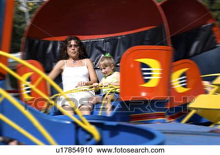 Stock Image - Mother and daughter on carnival ride. Fotosearch