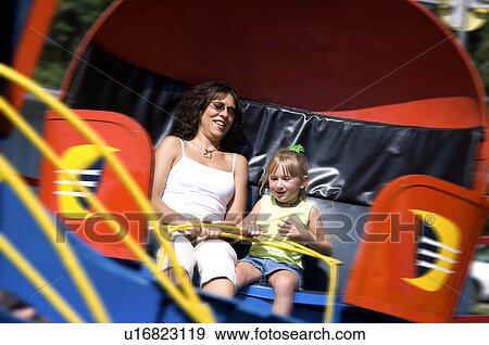 Stock Photo - Mother and daughter on carnival ride. Fotosearch