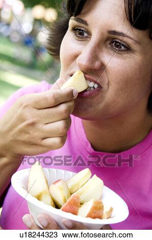 Woman eating bowl of candied apples View Large Photo Image Stock Image - Woman eating bowl of candied apples. Fotosearch