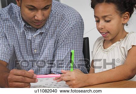 Stock Image - African American father helping daughter with homework. Fotosearch