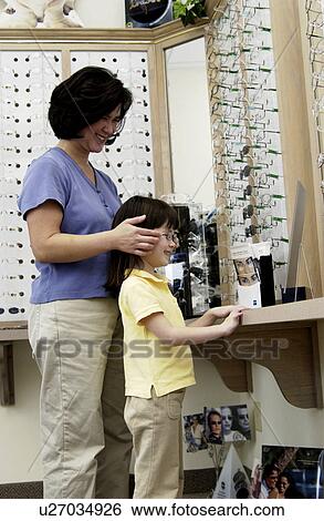 Asian mom and daughter choosing eyeglasses View Large Photo Image Stock Photograph - Asian mom and daughter choosing eyeglasses. Fotosearch