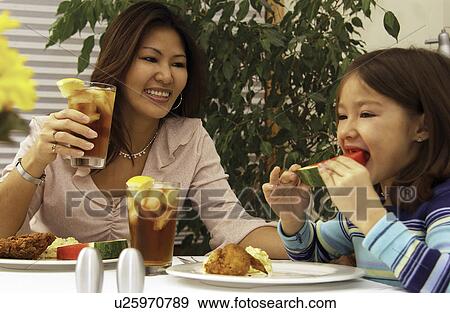 Stock Photo - Asian mom and daughter eating. Fotosearch
