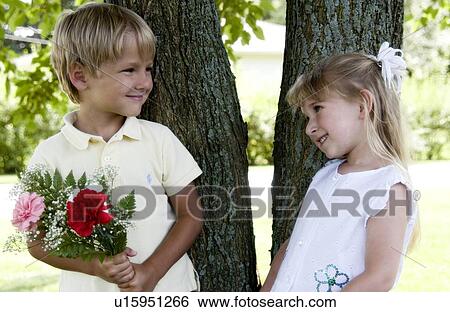 Stock Photograph - Boy giving girl flowers. Fotosearch