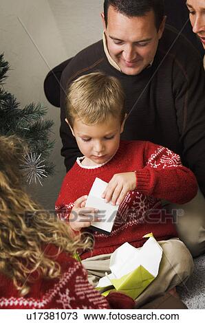 Family opening Christmas gifts View Large Photo Image Stock Image - Family opening Christmas gifts. Fotosearch