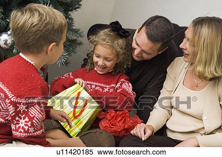 Family opening Christmas gifts View Large Photo Image Stock Photography - Family opening Christmas gifts. Fotosearch