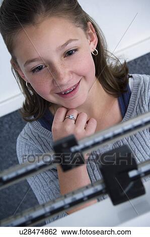 Stock Image - Girl on scale. Fotosearch