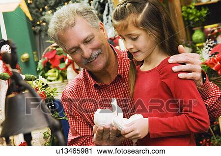 Stock Image - Grandpa and granddaughter christmas shopping. Fotosearch