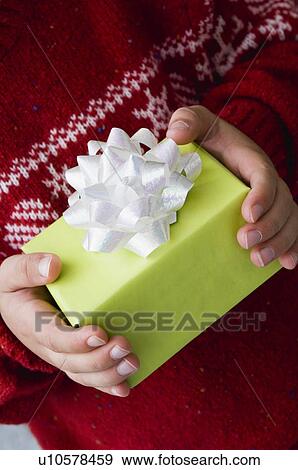 Child holding Christmas gift View Large Photo Image Stock Photo - Child holding Christmas gift. Fotosearch