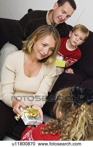 Stock Image - Family opening Christmas gifts. Fotosearch