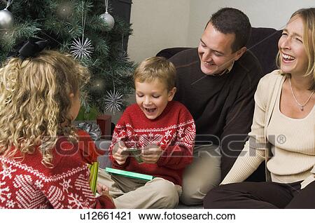 Family opening Christmas gifts View Large Photo Image Stock Image - Family opening Christmas gifts. Fotosearch