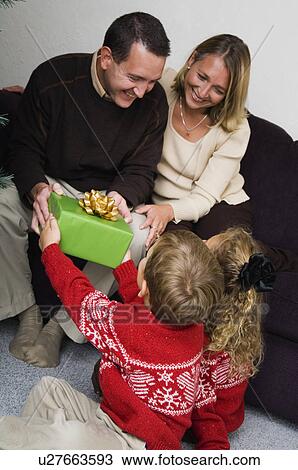 Stock Image - Family opening Christmas gifts. Fotosearch