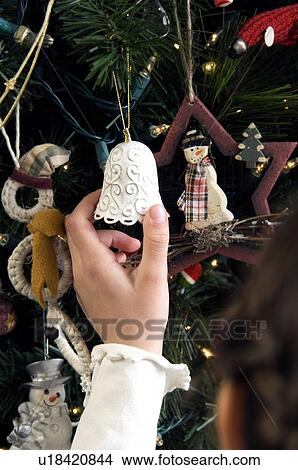 Picture - Girl hanging ornament. Fotosearch