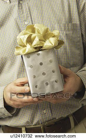 Stock Image - Man holding a gift. Fotosearch