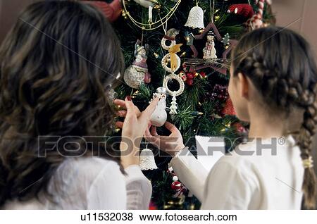Mom and daughter decorating a Christmas tree View Large Photo Image Stock Photo - Mom and daughter decorating a Christmas tree. Fotosearch