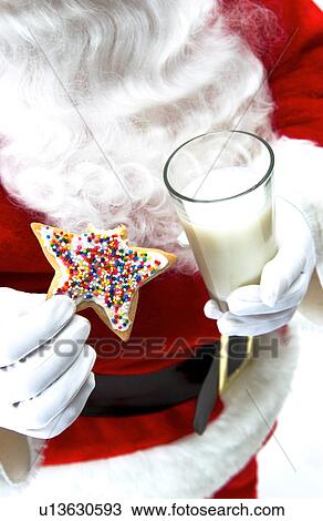 Stock Image - Santa with cookie and milk. Fotosearch