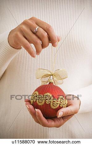 Stock Image - Woman holding ornament. Fotosearch