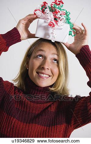 Stock Photo - Woman with gift on top of her head. Fotosearch